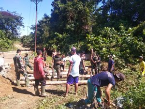TNI Bersama Warga Bangun Jalan Darurat dari Batang Kayu