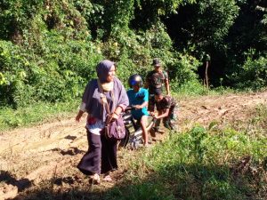 Pak Tentara Ini Bantu Warga Melewati Jalan Berlumpur di Desa Danti