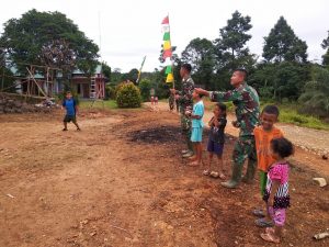 Anggota Satgas TMMD Bermain Layang-layang Bersama Anak-anak Desa Danti