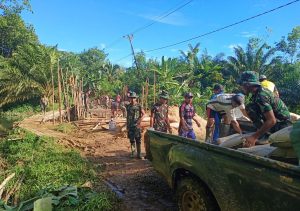 Kejar Target, Anggota TMMD 108 Bersama Warga Turunkan Bahan Material Pengecoran