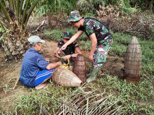 Hilangkan Penat, Anggota TMMD Bantu Kakek Boni Cari Ikan