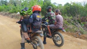 Anggota Satgas TMMD Kodim 1201 Bantu Lansia Bawa Hasil Kebun