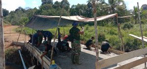 Anggota Satgas TMMD 110/Kodim 1201 Rancang Terpal Menjadi Atap Jembatan