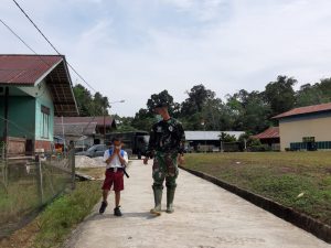 Anggota Kodim 1206/PSB Bantu Anak SD Pulang Sekolah di Saat Kegiatan TMMD Ke-110
