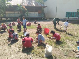 Anggota Satgas TMMD 110 Kodim 1206/PSB Bantu Bersihkan Halaman Sekolah